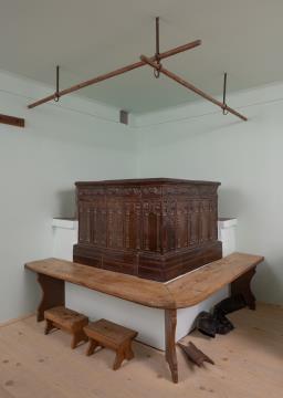 Kmečka peč s klopjo, sredina 19. st., lončena peč; vogalna klop iz smrekovine.